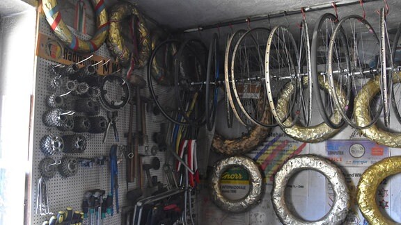 In einer Werkstatt hängen Siegerkränze und Fahrradfelgen.