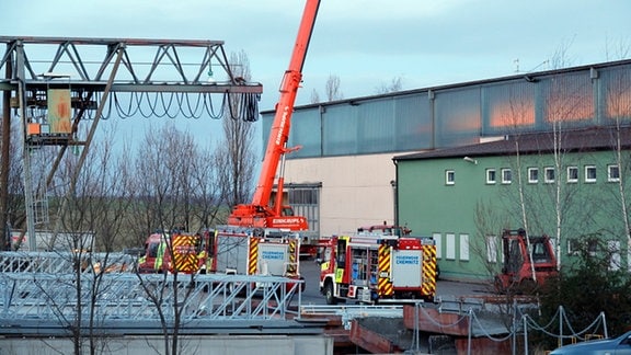 Vor einer großen Werkhalle steht ein Kran der Feuerwehr Chemnitz. Sie wurde zu einem Arbeitsunfall gerufen.