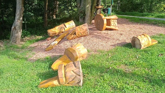 Umgestoßene Tische und Stühle aus Holz auf einer Wiese