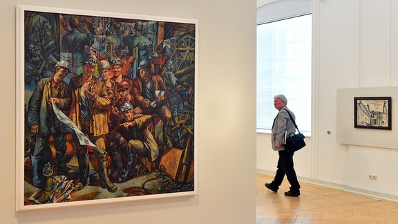 Ein quatdrratisches, großformatiges Gemälde zeigt eine Gruppe von Menschen in Arbeitskleidung, die Helme mit Lampen tragen. Das Werk stammt von Werner Petzold aus dem Jahr 1970 und trägt den Titel "Brigade Rose".