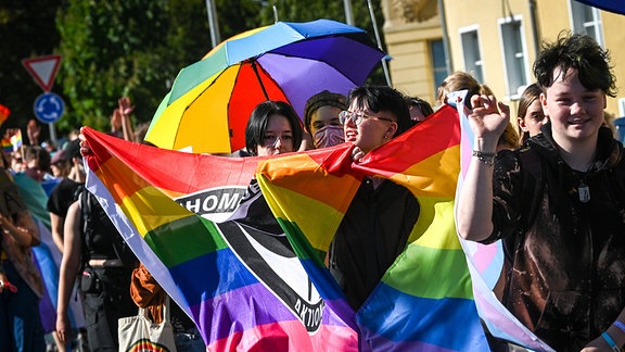 Teilnehmer des Christopher Street Day in Döbeln mit einer Regenbogenfahne.