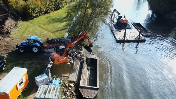 Ein Bagger hebt Sedimente aus einem Fluss