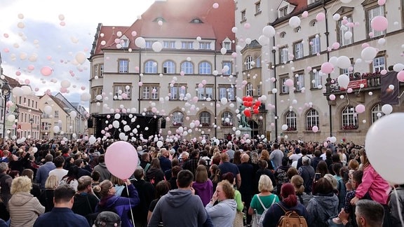Auf einem Platz in der Altstadt von Döbeln stehen hunderte Menschen und lassen als zeichen der stillen Trauer Luftballons steigen.