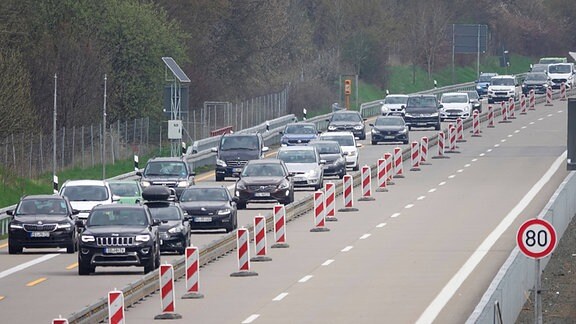 Autos fahren an einer Autobahn-Baustelle vorbei.