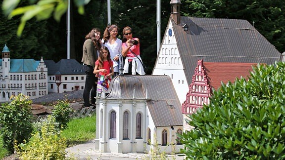 Besucher betrachten die Modelle des Freiberger Doms St. Marien und des Bergbaumuseums im Miniaturpark "Klein-Erzgebirge" in Oederan.