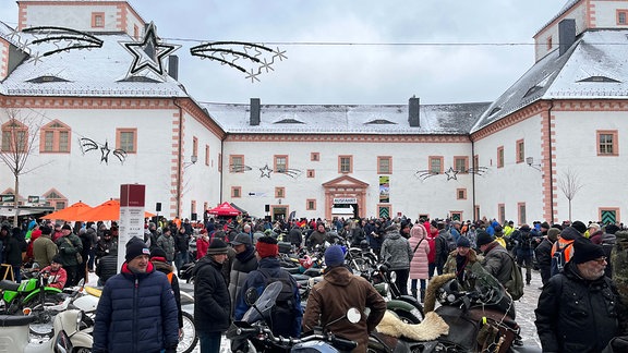 Motorradfreunde treffen sich in einem Schlosshof