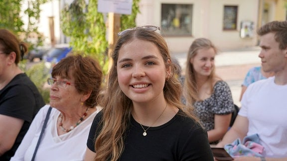 Eine junge Frau lächelt in die Kamera.