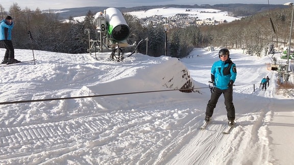 Ein Skifahrer wird den Hang heraufgezogen.