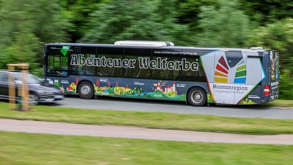 "Abenteuer Welterbe" steht auf einem fahrenden Linienbus.