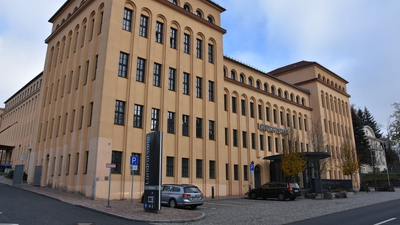 Außenansicht des Landratsamtes Mittelsachsen, ein ocker gestrichener Industriebau mit zwei Ecktürmen.