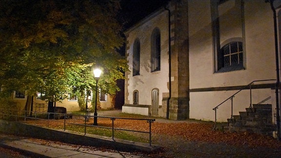 Eine einzelne Laterne leuchtet vor der dunklen Freiberger Nikolaikirche.