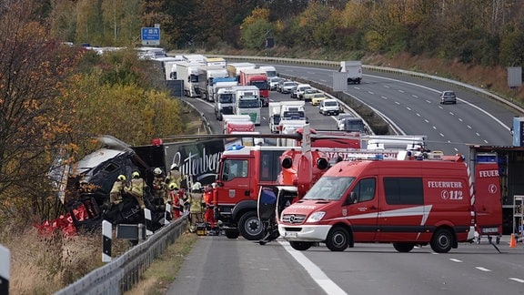 Unfallstelle an der A4: Laster umgeben von Rettungskräften, dahinter Stau auf Autobahn