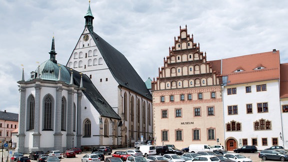 Autos stehen vor dem Stadt- und Bergbaumuseum (r) sowie dem Dom zu Freiberg.