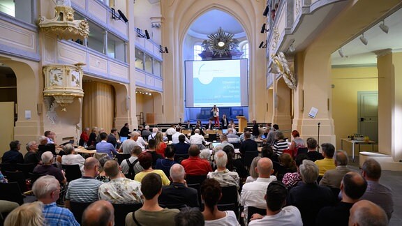 Gäste der Sitzung des Freiberger Stadtrates sitzen vor Beginn in der Konzert- und Tagungshalle Nikolaikirche.