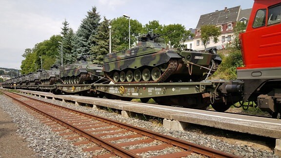Am Bahnhof Marienberg steht ein mit Panzern beladener Zug. 