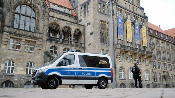 Ein Polizeifahrzeug steht vor dem Rathaus von Chemnitz