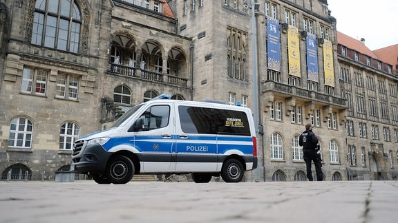 Ein Polizeifahrzeug steht vor dem Rathaus von Chemnitz