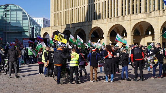 200 bis 300 Menschen sind bei einer Demo der rechtsextremen Kleinstpartei Freie Sachsen vor das Rathaus Chemnitz gekommen. Manche schwenken die typischen Flaggen der Partei.