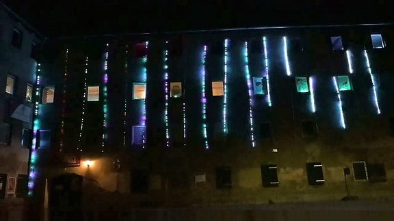 An einem Haus leuchten LED-Schlangen in verschiedenen Farben