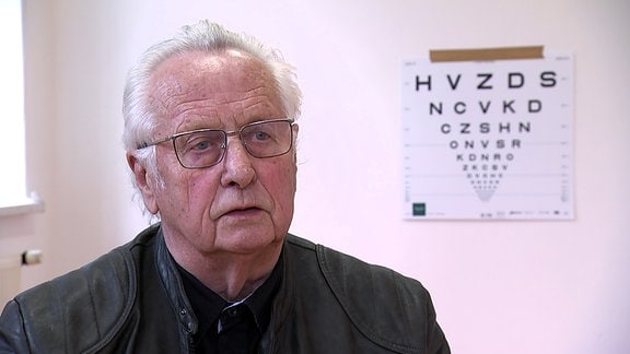 Mann vor einer Buchstabentafel beim Augenarzt