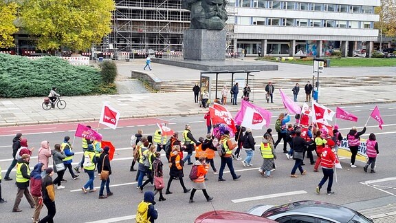 Etwa 50 Verdi-Mitglieder ziehen mit Plakaten und Transparenten am Karl-Marx-Monument in Chemnitz vorbei.