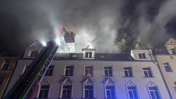 Die Feurwehr löscht einen Brand in einem Mehrfamilienhaus