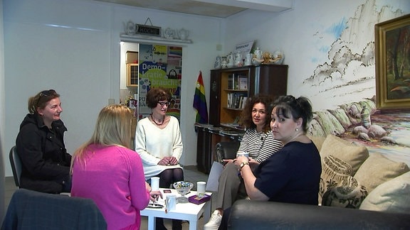 Fünf Frauen sitzen in kleiner Runde zusammen und trinken Tee.