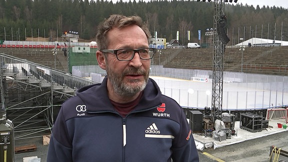 Alexander Ziron, Geschäftsführer der Vogtland Arena, vor einem Eishockey-Spielfeld.