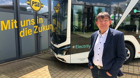 Der Chef der Plauener Straßenbahn, Karsten Treiber, steht vor einem Elektrobus.