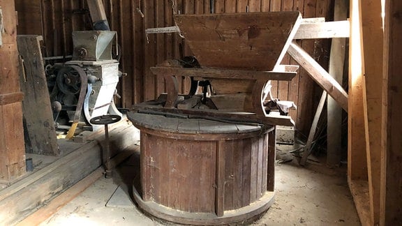 Ein zum Großteil erhaltenes Mahlwerk in einer alten Mühle mit Riementrieb.