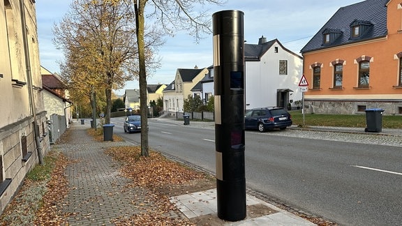 Eine Blitzersäule steht auf dem Fußweg.