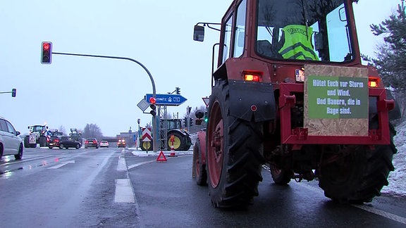 Ein Traktor mit einem Plakat am Heck blockiert eine Autobahnauffahrt an der A72.
