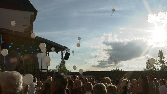 Weiße Luftballons steigen aus dem Schlosshof Schloss Voigtsberg in den Abendhimmel für den gestorbenen Sänger Eberhard Hertel.
