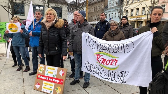 Auf dem Neumarkt in Auerbach im Vogtland stehen Demonstranten mit Plakaten für den Erhalt der Knorr-Werke.