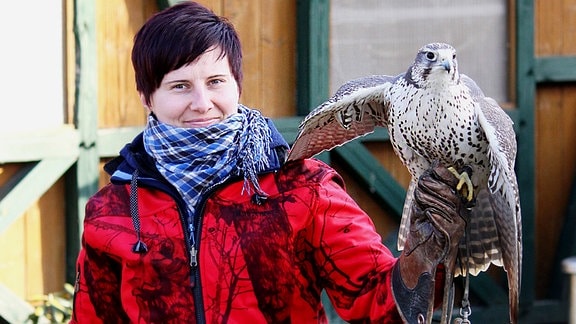 Tierärztin und Falknerin Christin Strahl-Thoß mit einem Greifvogel auf dem Arm.