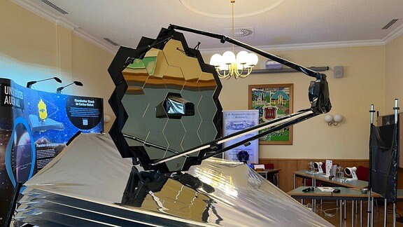 Ein Modell eines Teleskops steht in einem großen Raum.