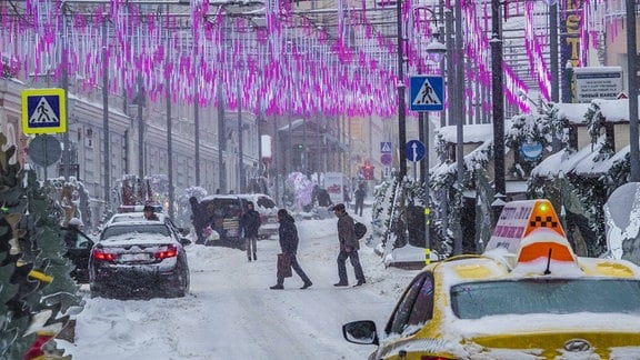 Menschen auf einer zugeschneiten Straße