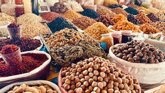 Körbe mit Nüssen und Früchten auf einem Markt.