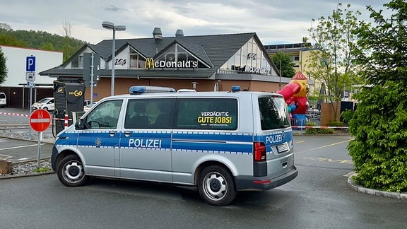 Ein Polizeiauto steht vor einem Schnellrestaurant. 