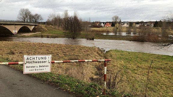 Ein Schild weist auf Hochwasser an der Zwickauer Mulde hin