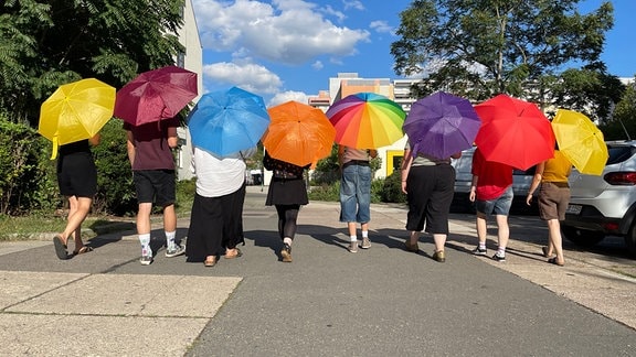 Junge Menschen mit bunten Regenschirmen