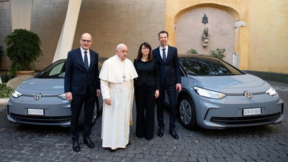 Papst Franziskus nimmt zwei E-Autos von VW im Vatikan in Empfang.  