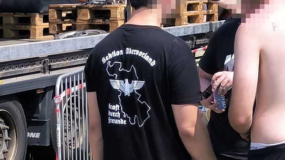 Ein Mann trägt ein "Kraft durch Freunde"-Shirt