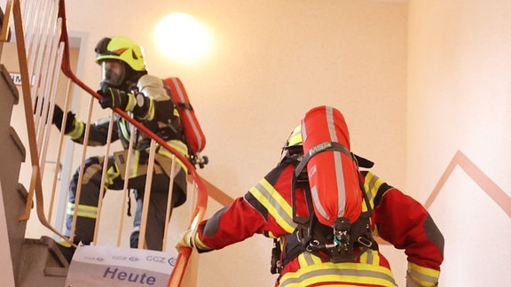 Feuerwehrmänner mit Atemschutzmaske und Sauerstoffflasche rennen eine Treppe hoch beim 10. Zwickauer Hochhaus-Treppenlauf und 5. Feuerwehr-Treppenlauf. 