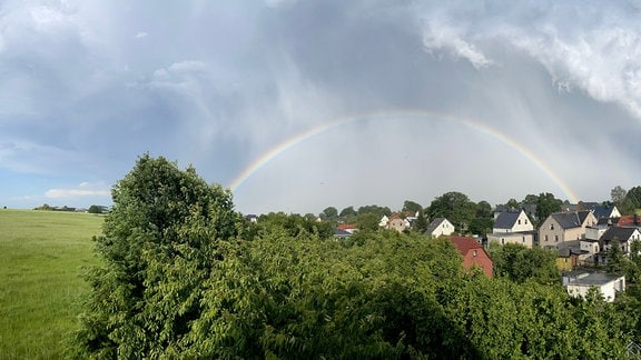 Ein Regenbogen hat sich bei Fraureuth unter einer wilden Wolkendecke gebildet.