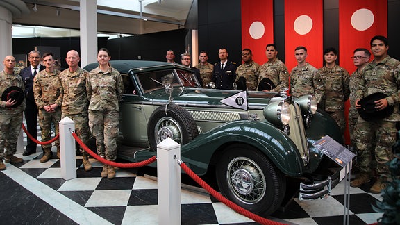 Eine Gruppe von US-Soldaten steht an einem Oldtimer im August-Horch-Museum Zwickau.