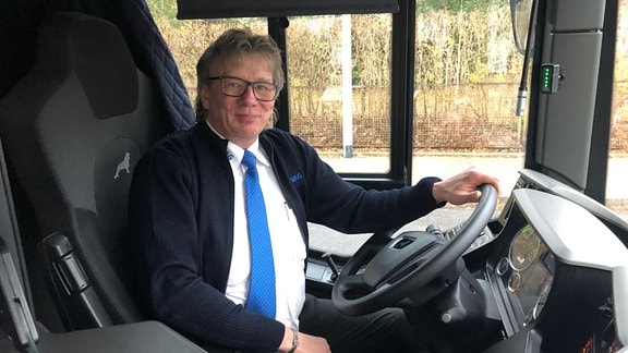 Ein Mann sitzt auf dem Fahrersitz eines Busses