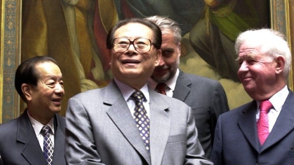 Lachend steht der chinesische Staatspräsident Jiang Zemin (M) am 11.04.2002 gemeinsam mit dem sächsischen Ministerpräsidenten Kurt Biedenkopf (r) in Dresden in der Gemäldegalerie Alte Meister vor dem Bild der Sixtinischen Madonna von Rafael. 