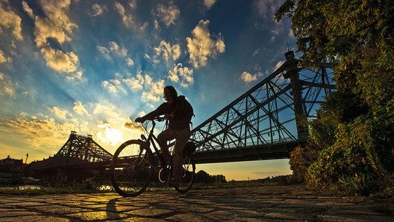 Radfahrer vor Brücke Blaues Wunder in Dresden Loschwitz