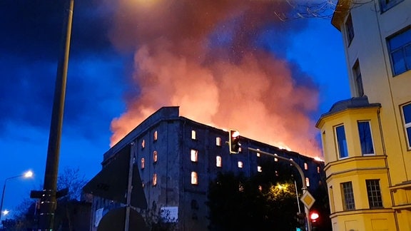 Eine leehrstehende Industriehalle steht in Flammen. 